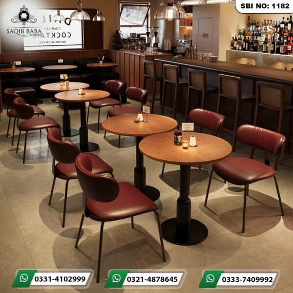Premium cafe table Pakistan with dark solid wood top and green chairs by Saqib Baba Interiors.