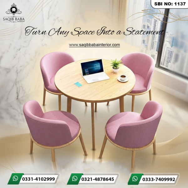 A round light-oak wooden table surrounded by four soft pink upholstered chairs with matching wooden legs, arranged in a modern office or cafe setting.