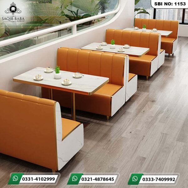 Premium restaurant booth seating sofas with mustard-orange leatherette upholstery and white marble-textured side panels by Saqib Baba Interior.
