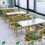 Luxury gold cafe dining set with green leather padded chairs and white marble top tables by Saqib Baba Interior