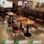 Premium cafe table Pakistan with dark solid wood top and green chairs by Saqib Baba Interiors.